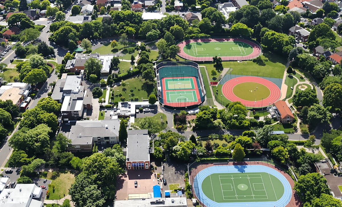 An aerial view of a suburban school campus with sports fields and surrounding streets.