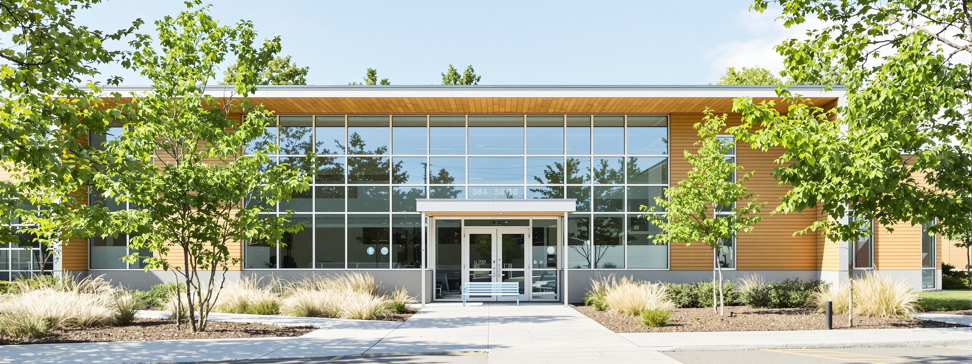 A modern single-storey school building with large windows and a planted courtyard